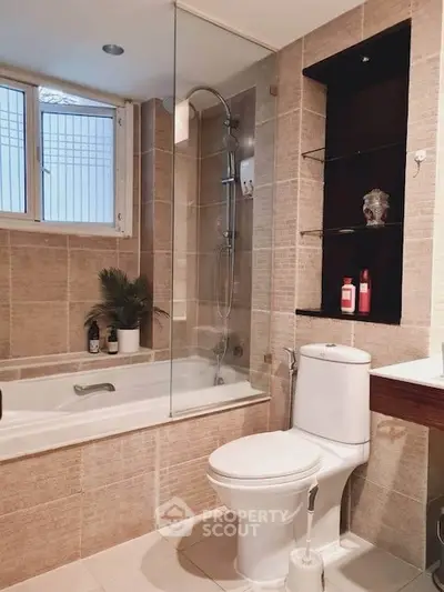 Modern bathroom with bathtub and shower, featuring elegant tile design and natural light.