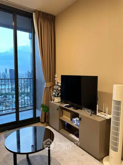Modern living room with city view, featuring sleek TV setup and elegant balcony access.