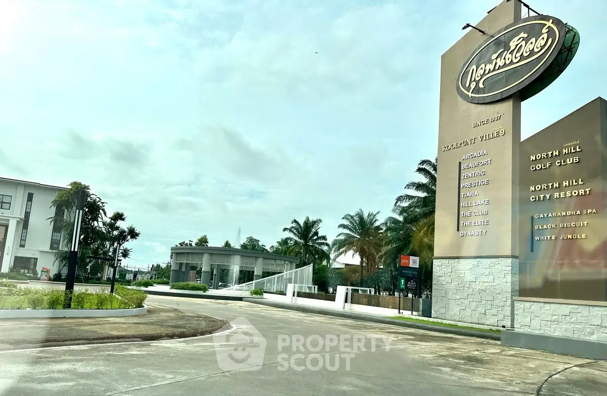 Luxurious resort entrance with palm trees and elegant signage, showcasing premium amenities and lush surroundings.