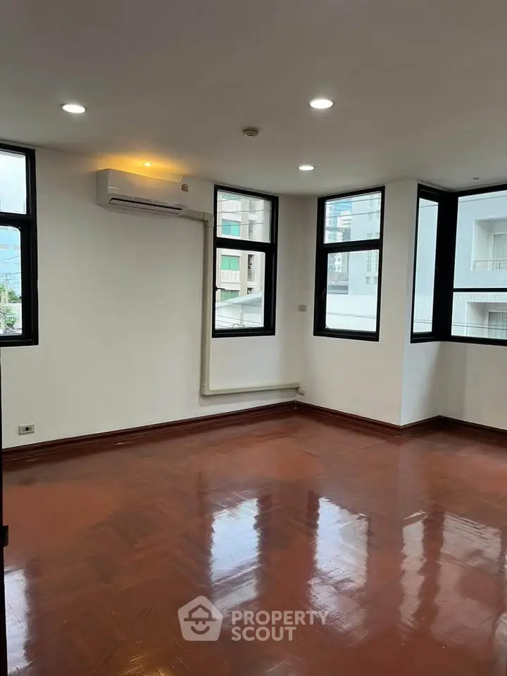 Spacious corner unit with large windows and polished wooden floors