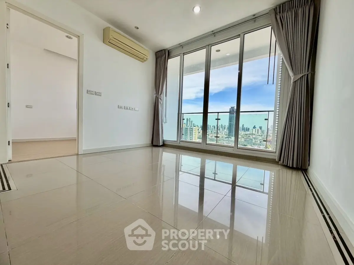Spacious living room with large windows offering stunning city views and abundant natural light.