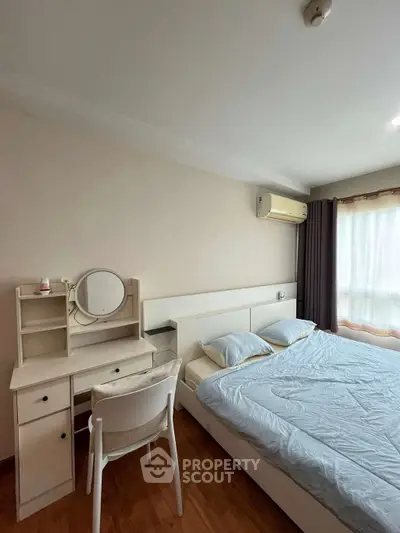 Cozy bedroom with modern furniture and natural light, featuring a comfortable bed and stylish vanity desk.