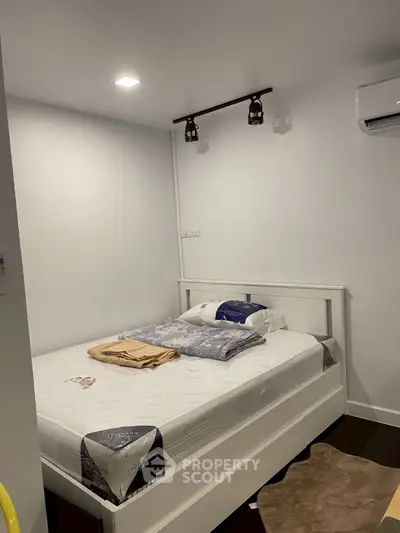 Cozy bedroom with modern lighting and air conditioning, perfect for restful nights.
