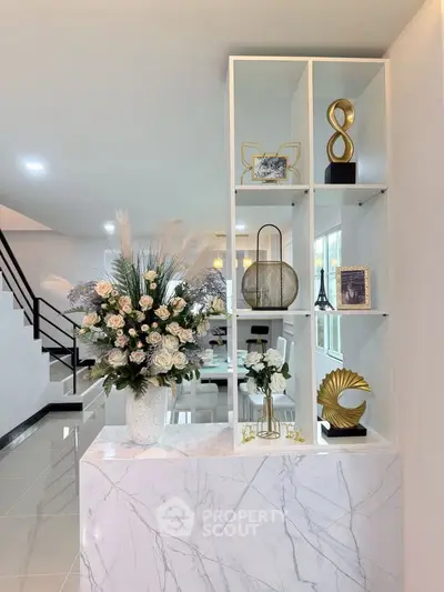 Elegant modern interior with decorative shelving and floral arrangement