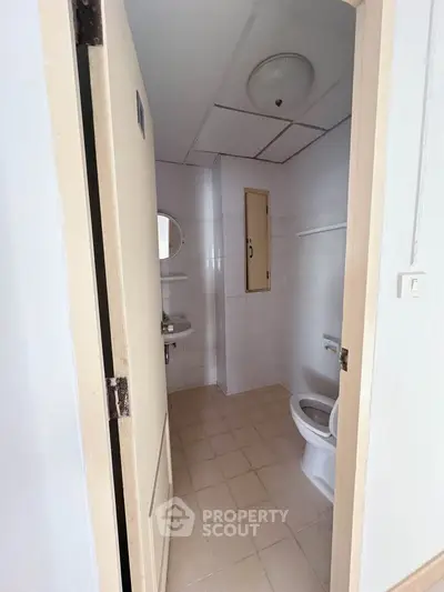 Compact bathroom with tiled floor and basic fixtures