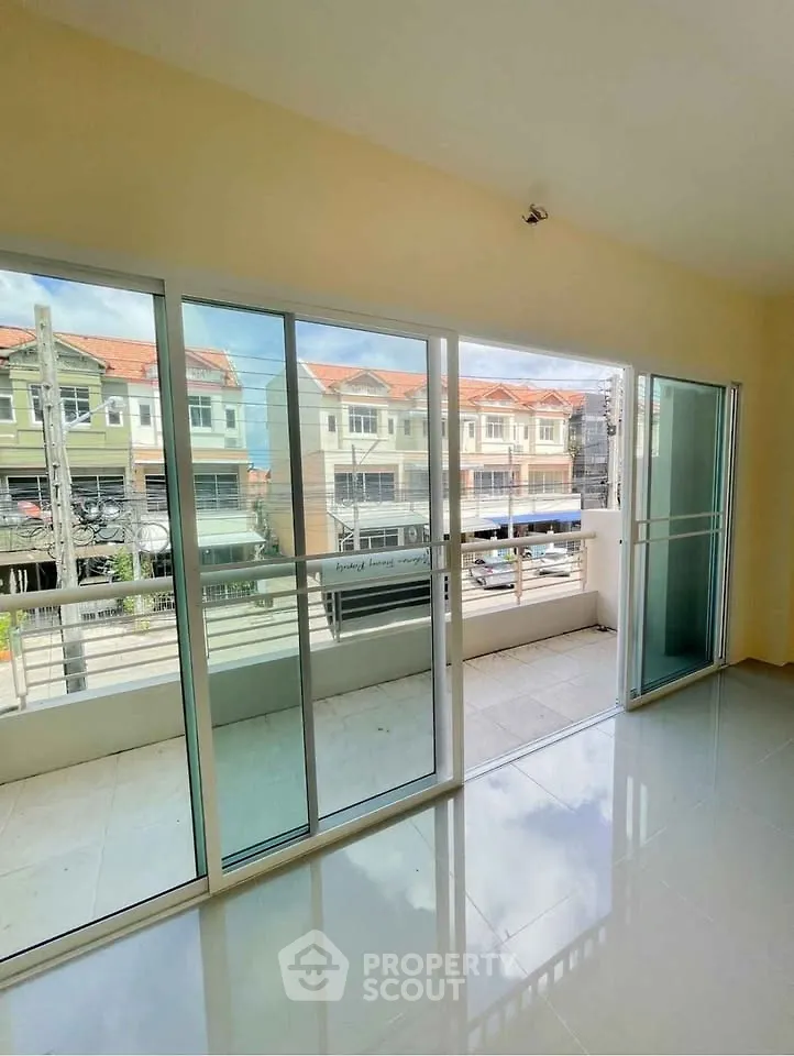 Spacious living room with large glass doors opening to a balcony, offering a bright and airy atmosphere.
