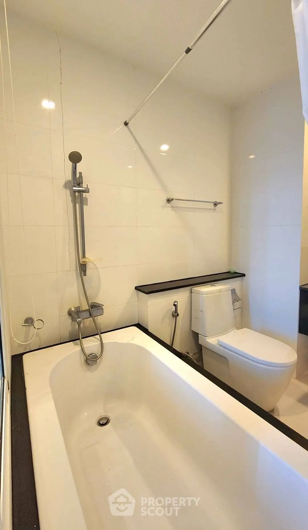Modern bathroom with sleek bathtub and contemporary fixtures in a stylish apartment.