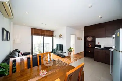 Modern open-layout living room and kitchen with wooden furniture and balcony view.