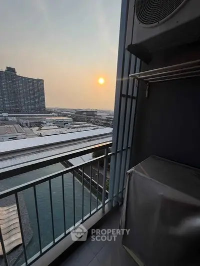 Stunning balcony view with sunset over cityscape and waterway.