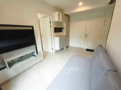 Modern living room with sleek design and neutral tones, featuring a wall-mounted TV and stylish cabinetry.