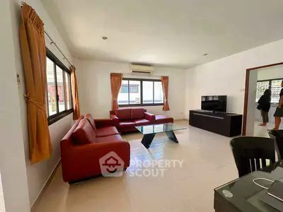 Spacious living room with red sofa and modern decor, perfect for family gatherings.