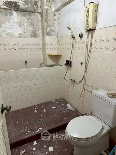 Fixer-upper bathroom with shower and toilet, needs renovation