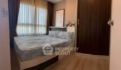 Cozy bedroom with large window and modern furnishings in a stylish apartment.