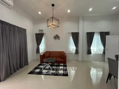 Spacious modern living room with elegant chandelier and cozy seating area, perfect for relaxation.