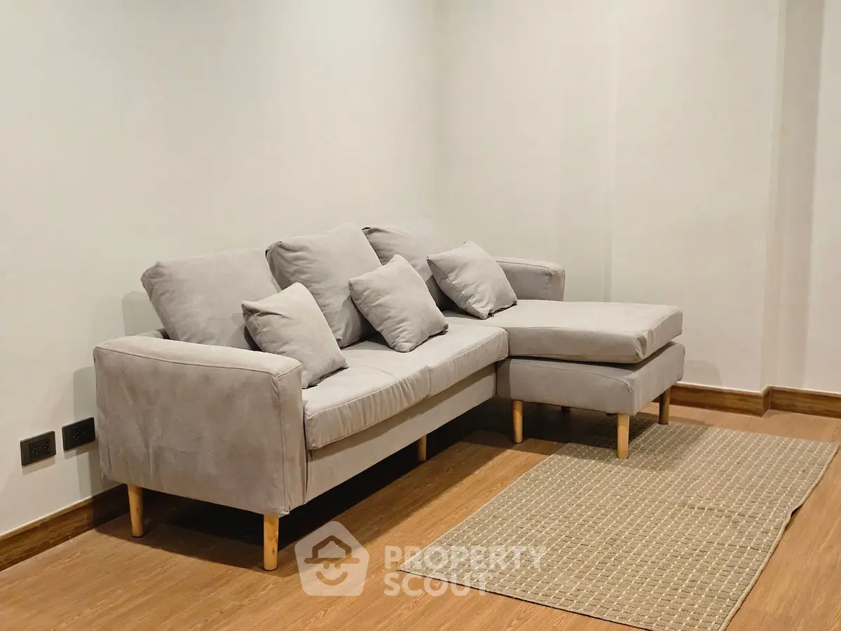 Cozy living room with modern gray sectional sofa and wooden flooring