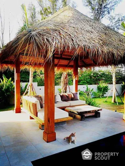 Tropical outdoor gazebo with lush garden and cozy seating area