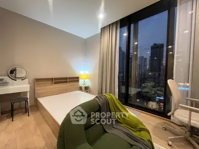 Modern bedroom with city view, featuring stylish furniture and large windows for natural light.