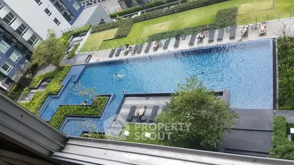 Luxurious apartment complex with stunning rooftop pool and lush greenery.