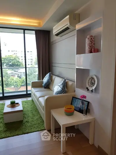 Modern living room with large windows and stylish decor in a high-rise apartment.