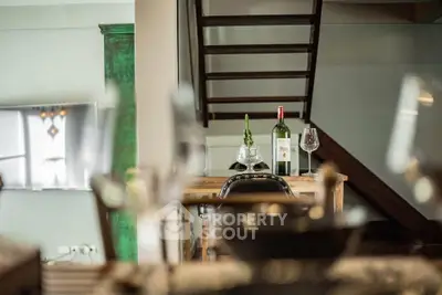 Stylish modern interior with elegant dining setup and staircase, perfect for urban living.