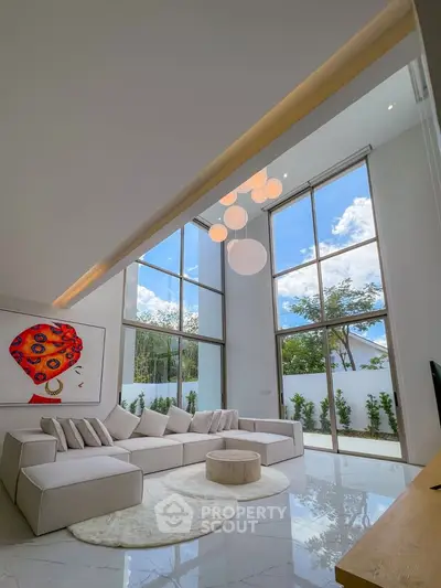 Luxurious living room with high ceilings and large windows offering stunning views.