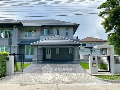 Modern two-story house with spacious driveway and sleek design.
