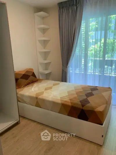 Cozy bedroom with single bed and modern decor, featuring floor-to-ceiling window and elegant curtains.
