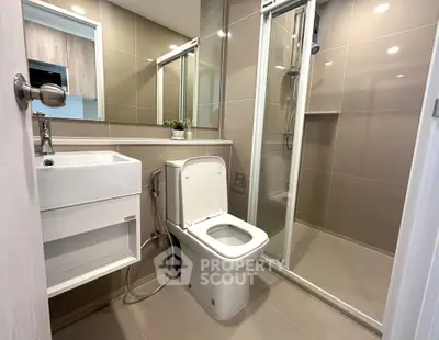 Modern bathroom with sleek design, featuring a glass shower and contemporary fixtures.