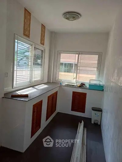 Bright kitchen with large windows and wooden cabinets, ideal for natural light lovers.