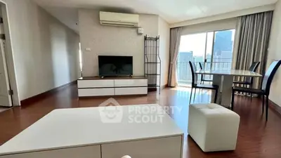 Spacious living room with modern furniture and city view balcony.