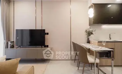 Modern living room with sleek TV setup and stylish dining area in open layout apartment.
