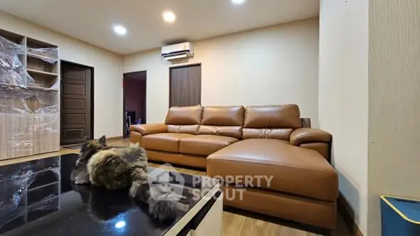 Spacious living room with modern leather sofa and cozy ambiance.