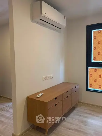 Modern interior with sleek wooden cabinet and air conditioning unit, perfect for a cozy living space.