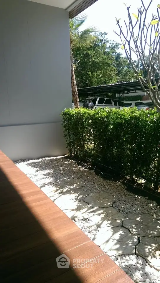 Charming garden view with lush greenery and wooden deck, perfect for relaxation.