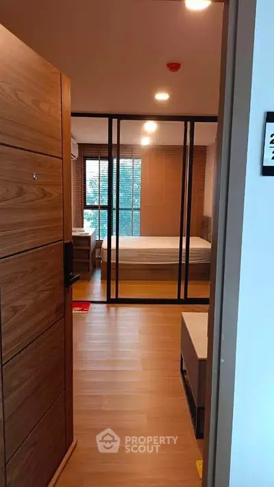 Modern bedroom with wooden flooring and large window for natural light