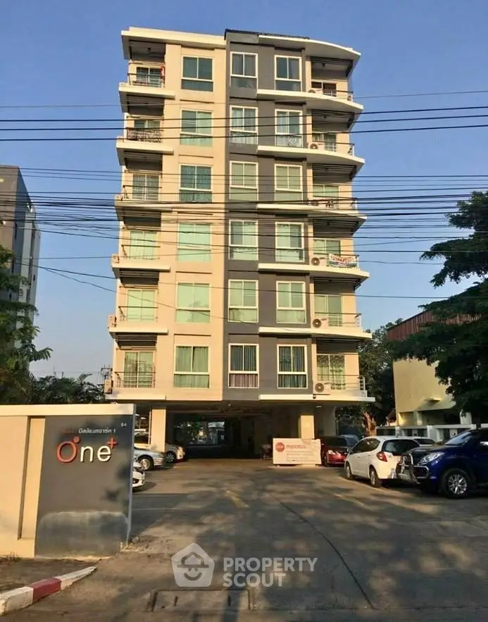 Modern apartment building with parking area and clear blue sky