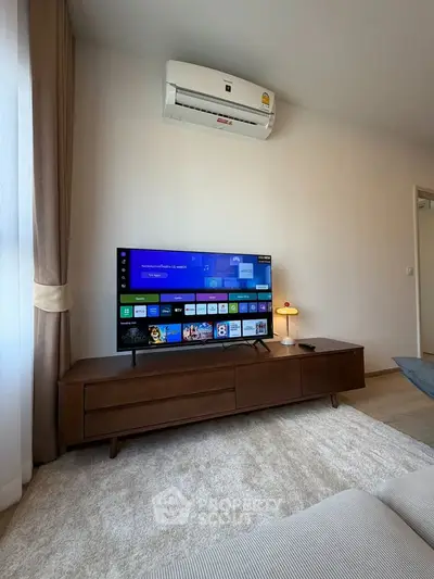 Modern living room with sleek TV setup and air conditioning, perfect for relaxation.