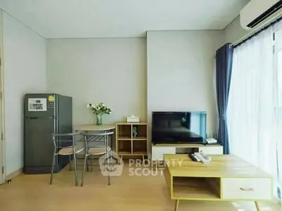 Modern living room with dining area, featuring sleek furniture and natural light.