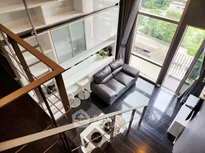 Modern loft apartment with mezzanine, large windows, and sleek interior design.
