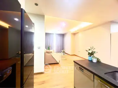 Modern open-layout kitchen and living room with sleek design and bright lighting.