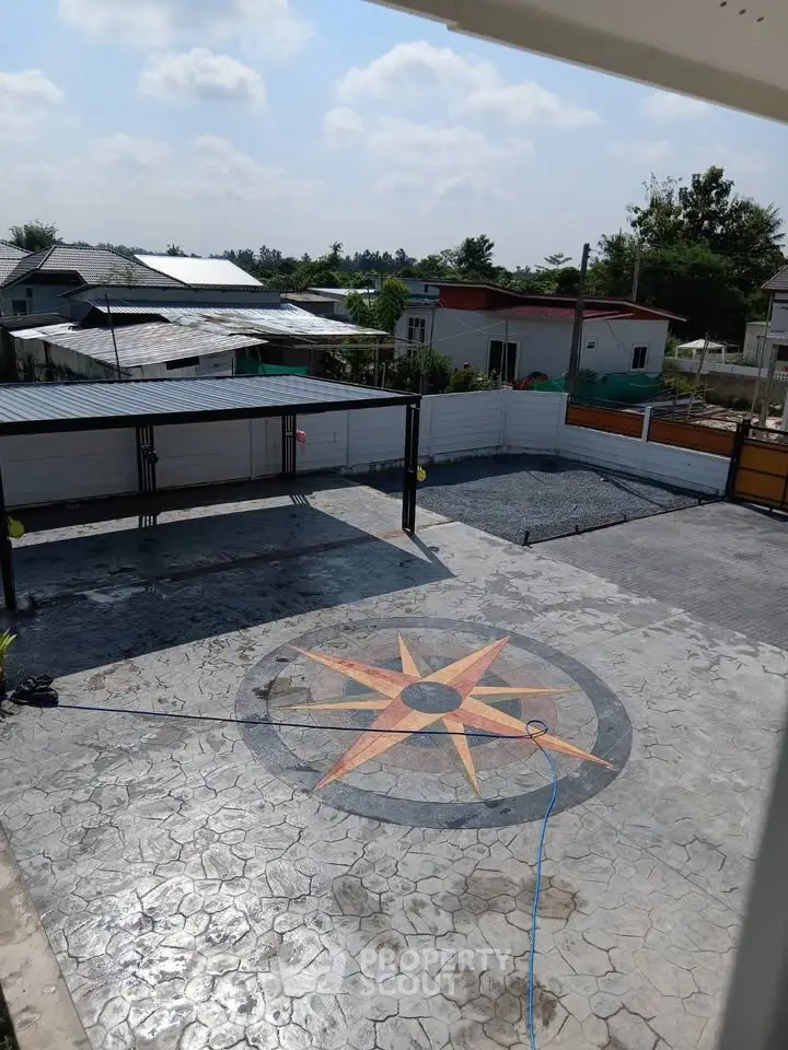 Spacious outdoor area with decorative compass design on concrete, ideal for gatherings and leisure.