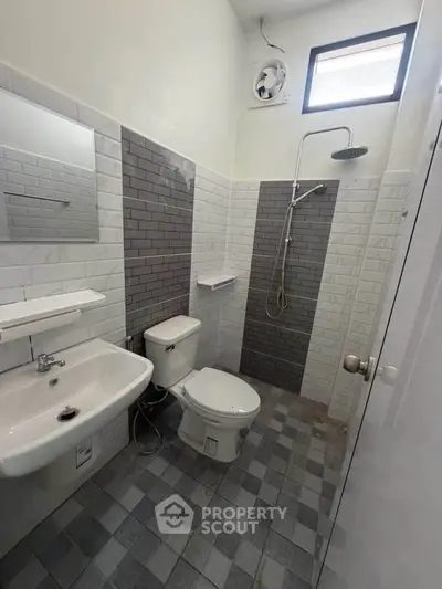 Modern bathroom with sleek tiles and contemporary fixtures in a stylish real estate property.