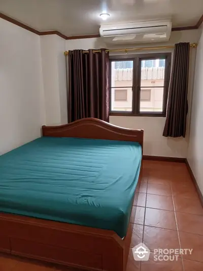 Cozy bedroom with terracotta tiled flooring, classic wooden bed frame, and air conditioning unit, ideal for comfortable living.