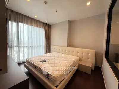 Spacious bedroom with large windows and modern furnishings