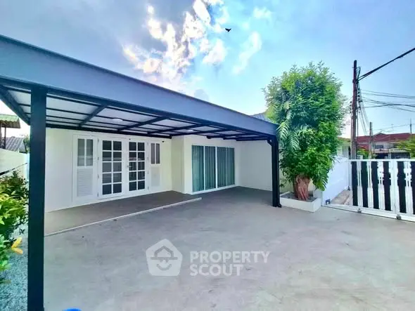 Spacious modern home exterior with covered patio and lush greenery