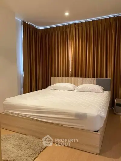 Cozy bedroom with elegant curtains and a comfortable bed in a modern apartment.