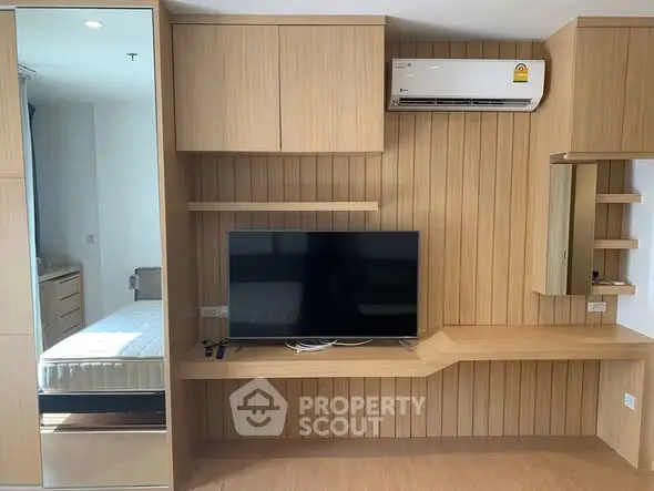 Modern living room with built-in wooden furniture and wall-mounted TV