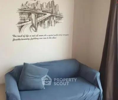 Cozy living room with blue sofa and artistic wall mural, perfect for urban living.