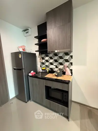 Modern kitchen with sleek cabinetry, stylish backsplash, and built-in appliances in a compact layout.