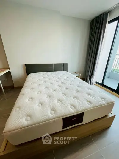 Spacious bedroom with modern design and large window for natural light.